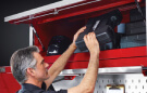 Man putting tools into an Icon Tool Storage Overhead Cabinet
